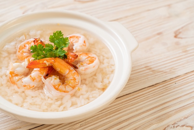 Mingau ou sopa de arroz cozido com tigela de camarão