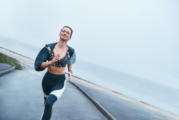 Minha motivação diária, mulher forte e feliz com deficiência em roupas esportivas é correr ao ar livre perto do