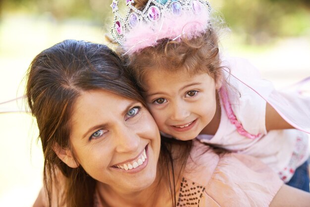 Minha princesinha Foto recortada de uma linda mulher e sua filha brincando ao ar livre