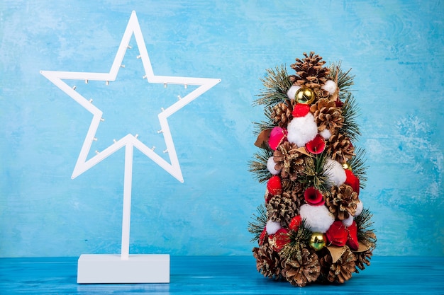 Mini árbol de Navidad sobre fondo azul en foto de estudio. Estacional y festivo