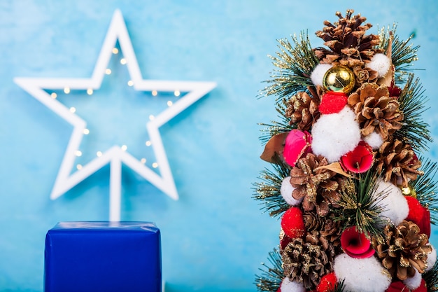 Mini árbol de Navidad sobre fondo azul en foto de estudio. Estacional y festivo