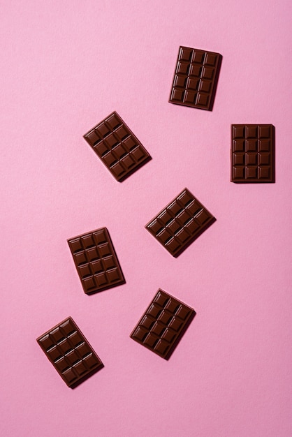 Mini barras de chocolate sobre un fondo rosa