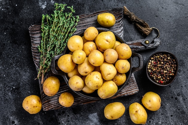 Mini batatas inteiras jovens em uma panela.