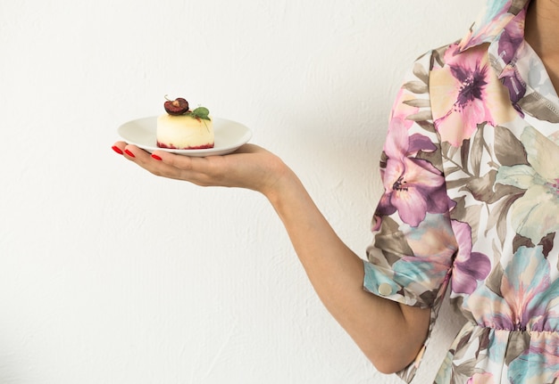 Mini bolo ou cheesecake nas mãos da mulher, sobremesa para o dia dos namorados