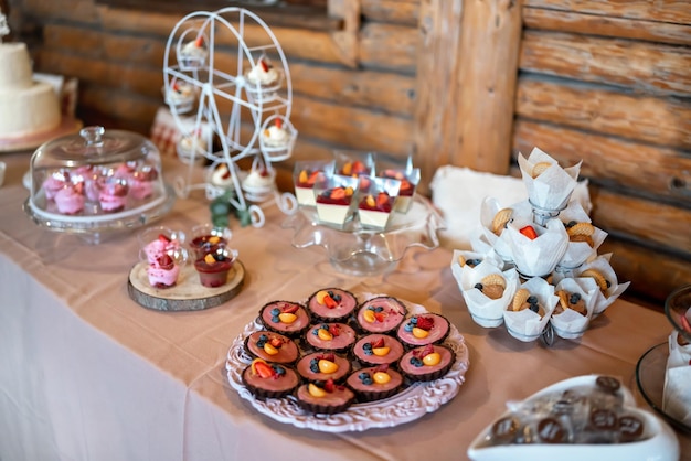 Mini bolos, biscoitos e doces exibidos na mesa, profundidade rasa da foto de campo