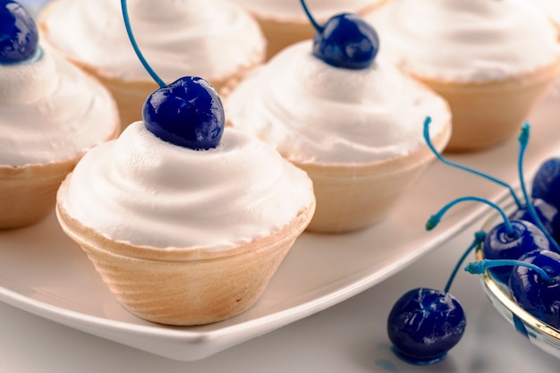 Mini bolos com queijo creme decorado bagas de cereja em conserva azul