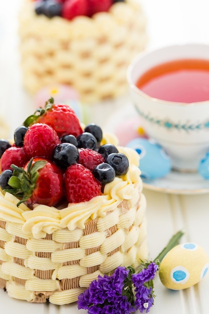 Mini bolos de cesta de Páscoa com frutas frescas glaceadas por cima.