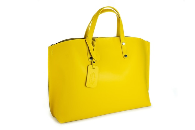 Mini bolsa feminina de couro amarelo com alça superior isolada no fundo branco vista frontal da bolsa de compras feminina alça superior feminina cadeado cadeado