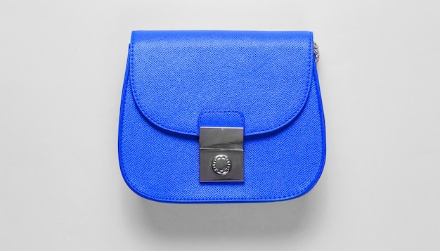 Mini bolso de piel azul sobre fondo azul. Concepto de moda minimalista. Vista superior