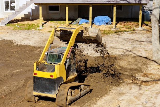 Mini bulldozer landschaftsbau arbeitet am bau arbeiten mit der erde dabei