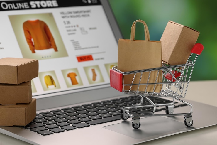 Foto mini cajas de bolsas de compras y carrito en la tienda en línea de primer plano de la computadora portátil