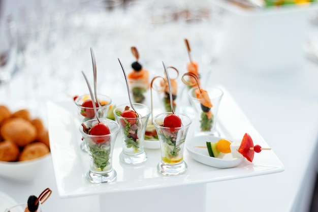 Mini Canapé con carne y verduras en vasos de vidrio sobre la mesa negra