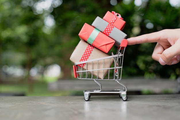 Mini carrinho de compras com caixas de presente.