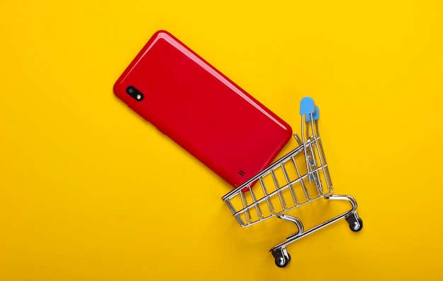 Mini carrito de la compra con smartphone en amarillo