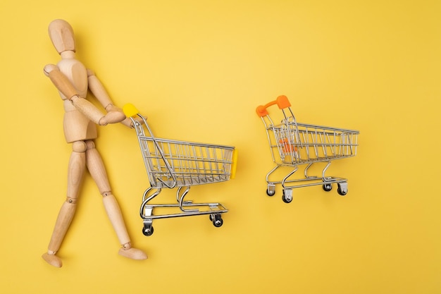 Mini carrito de compras con anuncio de maniquí de madera para regalo de todos o concepto de composición Espacio de copia