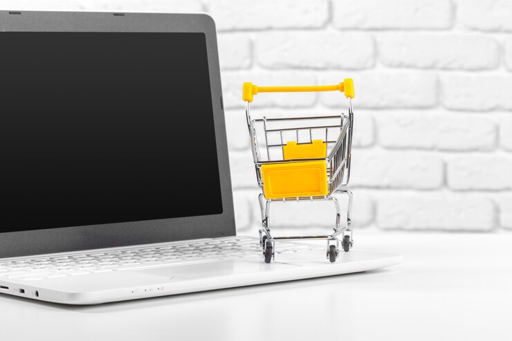 Foto mini carrito de compras y computadora portátil