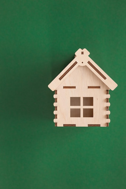Mini casa de madeira em fundo verde conceito de residência e empréstimo da casa