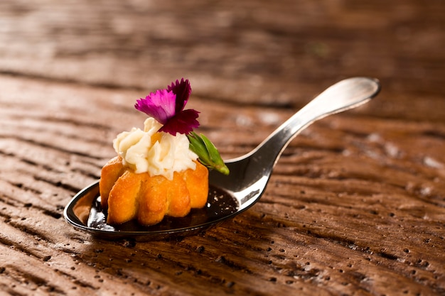 Mini churros salgados, acompanhados de redução de café aromatizado com Kombu e recheado com cream cheese de laranja cristalizada na colher. Prove petiscos gastronômicos