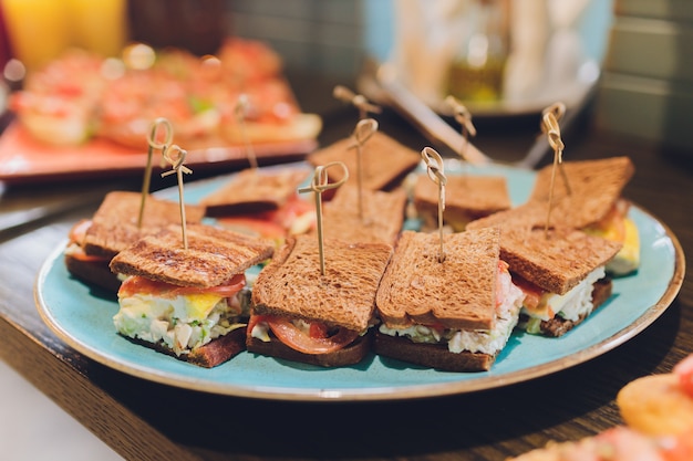 Mini club sándwiches con pollo, tocino y huevos.