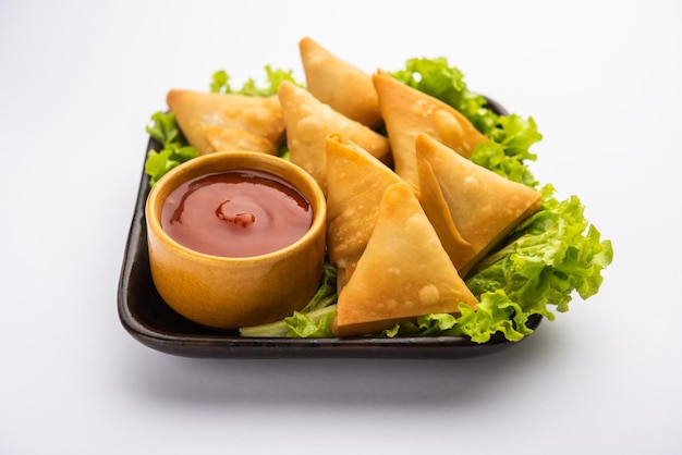 Mini cóctel samosa triangular elaborado con patti o strip, un aperitivo casero popular de la India