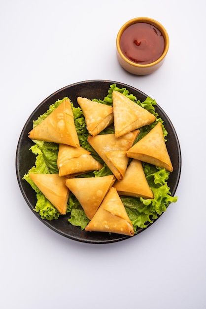 Mini cóctel samosa triangular elaborado con patti o strip, un aperitivo casero popular de la India