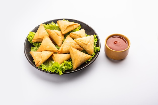 Mini cóctel samosa triangular elaborado con patti o strip, un aperitivo casero popular de la India