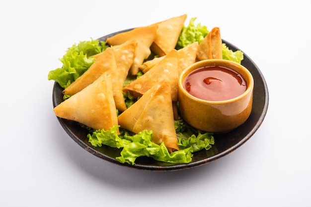 Mini cóctel samosa triangular elaborado con patti o strip, un aperitivo casero popular de la India