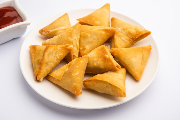 Mini cóctel samosa triangular elaborado con patti o strip, un aperitivo casero popular de la India