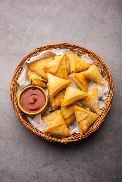 Mini cóctel samosa triangular elaborado con patti o strip, un aperitivo casero popular de la India