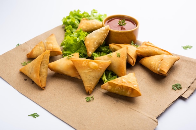 Mini cóctel samosa triangular elaborado con patti o strip, un aperitivo casero popular de la India