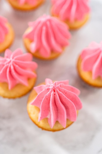 Mini cupcakes de baunilha com cobertura de creme de manteiga rosa