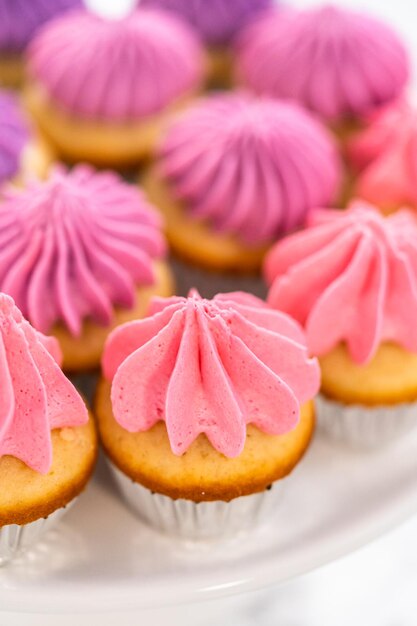 Foto mini cupcakes de baunilha com cobertura de creme de manteiga rosa