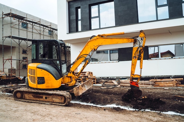 Mini escavadeira pesada movendo terra para construção de fundações Maquinaria industrial em canteiro de obras