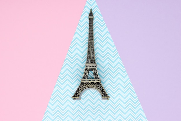 Mini estatueta da Torre Eiffel em uma mesa de papel pastel. Vista do topo