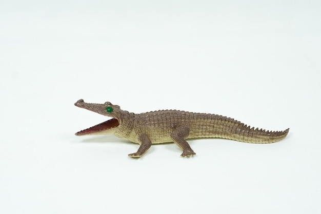 Mini figura de cocodrilo aislada sobre fondo blanco. Juguetes de animales de plástico.