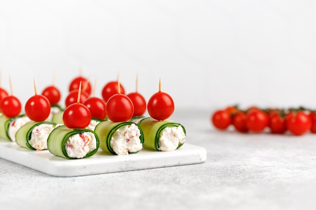 Mini frische Häppchen Vorspeise Gurkenröllchen gefüllt mit Frischkäse Snack für einen festlich gedeckten Tisch