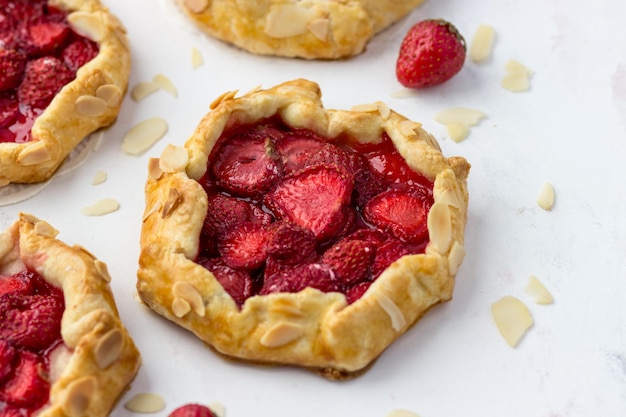 Mini galletas con fresas Pequeños pasteles de bayas sobre un fondo blanco.