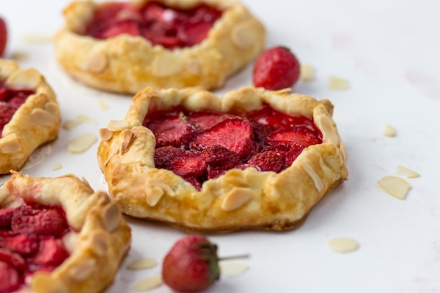 Mini galletas con fresas Pequeños pasteles de bayas sobre un fondo blanco.