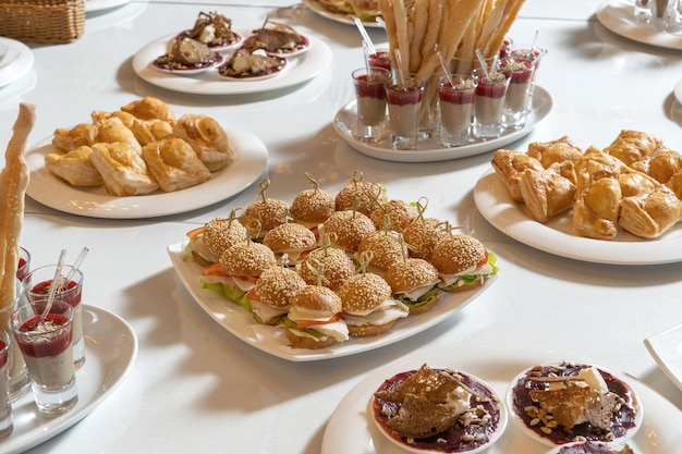 Mini hambúrgueres de frango com queijo e tomate em um prato branco Ligado com belas varas de bambu