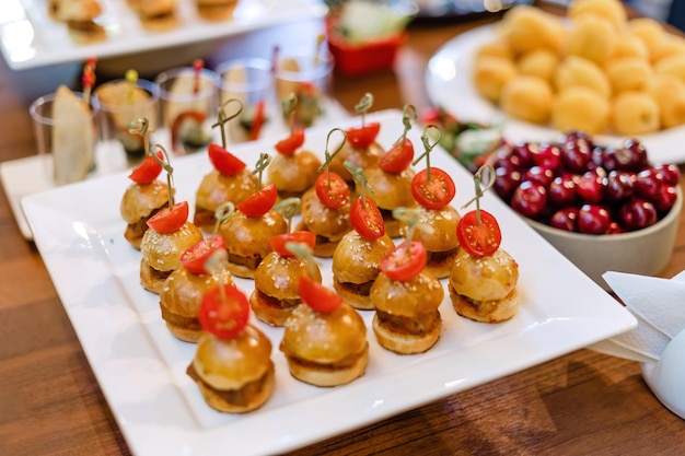 Mini hambúrgueres de frango na chapa branca uma bela mesa com catering em frutas de fundo