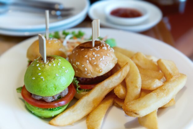 Mini hamburguesa en plato blanco.