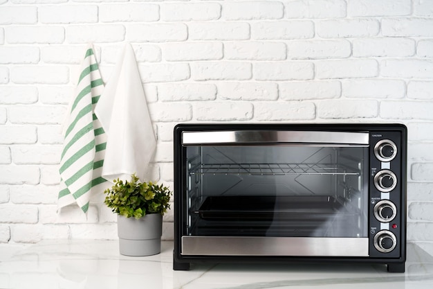 Mini horno eléctrico contra la pared de ladrillo blanco en la cocina