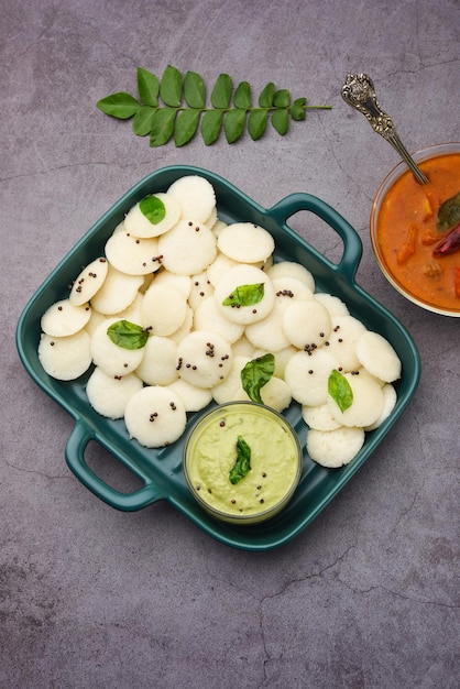 Mini idli es la versión más pequeña de idli de arroz regular al vapor de forma redonda, suave y esponjosa, también conocido como botón y cóctel idly