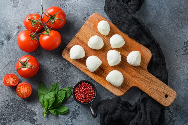 Mini-Kugeln aus Mozzarella-Käse, auf Holzbrett hacken