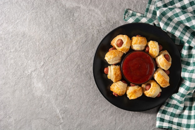 Mini linguiças embrulhadas em massa folhada com molho de ketchup