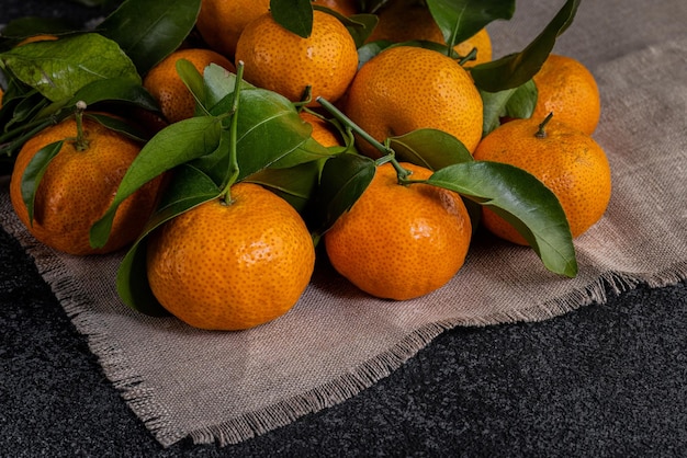 Foto mini-mandarinen auf canvas-stoff auf dunklem strukturiertem hintergrund