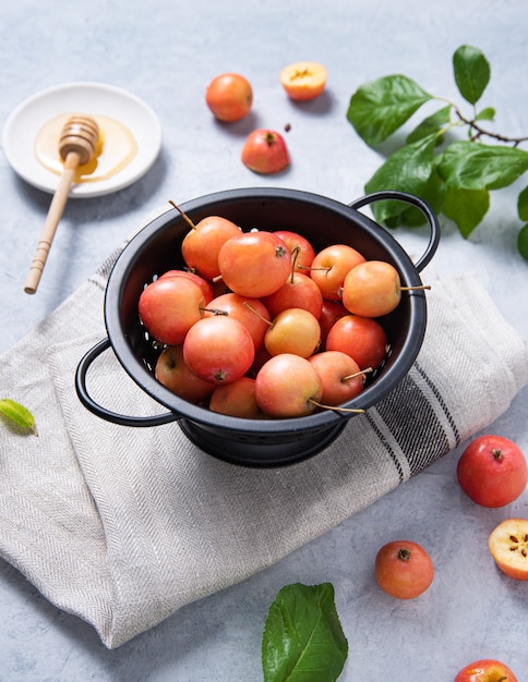 Mini manzanas jugosas se encuentran en un recipiente sobre una toalla de lino.