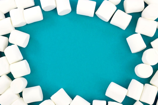 Foto mini-marshmallows auf blauem hintergrund mit einem geometrischen muster