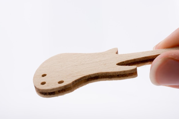 Mini modelo de guitarra de madera en mano.