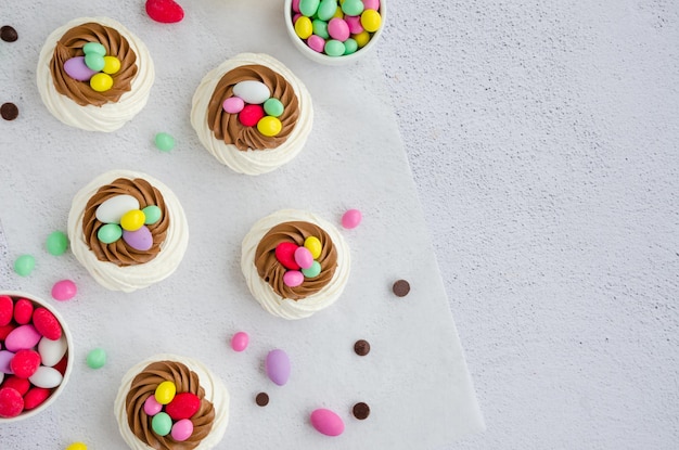 Mini nido de pájaro Pavlova con crema de chocolate y caramelos de colores Idea de comida para niños Tarta de Pascua